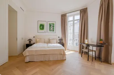 a bedroom with a bed and a desk and a window at La Guitare 22 - Spacious 1 BR apartment in the center of Cannes, right behind Grand Hotel in Cannes
