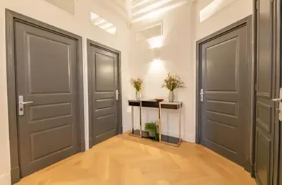 a hallway with two doors and a table with plants at La Guitare 22 - Spacious 1 BR apartment in the center of Cannes, right behind Grand Hotel in Cannes