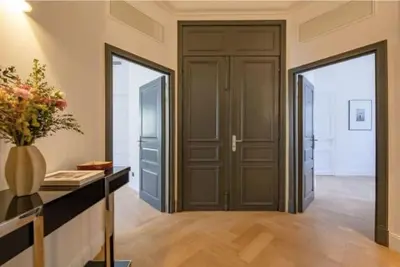 a hallway with a door and a vase of flowers at La Guitare 22 - Spacious 1 BR apartment in the center of Cannes, right behind Grand Hotel in Cannes