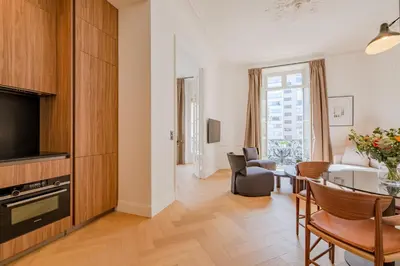 a living room with a table and a dining room at La Guitare 22 - Spacious 1 BR apartment in the center of Cannes, right behind Grand Hotel in Cannes