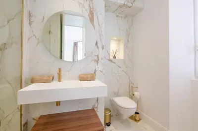 a white bathroom with a sink and a toilet at La Guitare 22 - Spacious 1 BR apartment in the center of Cannes, right behind Grand Hotel in Cannes