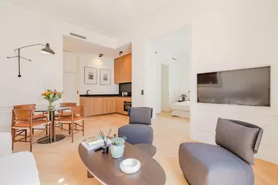 a living room with a couch and a table at La Guitare 22 - Spacious 1 BR apartment in the center of Cannes, right behind Grand Hotel in Cannes