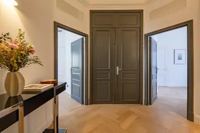 a hallway with a door and a vase of flowers at La Guitare 23 - Large modern studio with balcony in center of Cannes, just behind Grand Hotel in Cannes