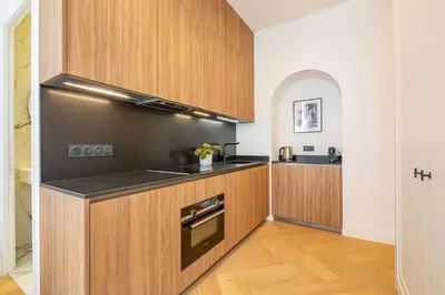 a kitchen with wooden cabinets and a counter top at La Guitare 23 - Large modern studio with balcony in center of Cannes, just behind Grand Hotel in Cannes