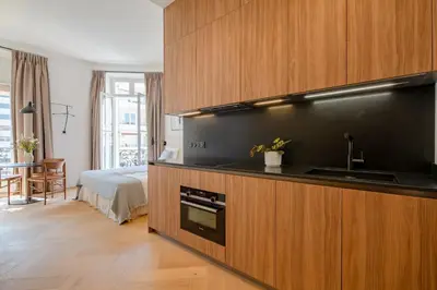 a kitchen with a sink and a bed in a room at La Guitare 23 - Large modern studio with balcony in center of Cannes, just behind Grand Hotel in Cannes