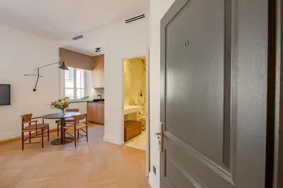 a hallway with a door leading to a kitchen with a table at La Guitare 24 - Nice studio in center of Cannes, just behind Grand Hotel in Cannes