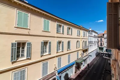 a row of buildings with green and white windows at La Guitare 24 - Nice studio in center of Cannes, just behind Grand Hotel in Cannes