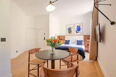 a room with a bed and a table and chairs at La Guitare 24 - Nice studio in center of Cannes, just behind Grand Hotel in Cannes