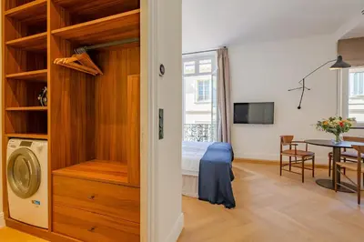 a room with a bed and a dining room with a table at La Guitare 24 - Nice studio in center of Cannes, just behind Grand Hotel in Cannes