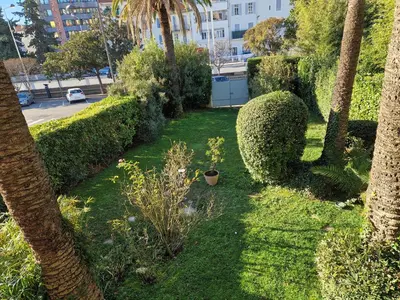 a garden with bushes and trees and a lawn with plants at Cannes près Croisette beau 2 pièces 3 étoiles in Cannes