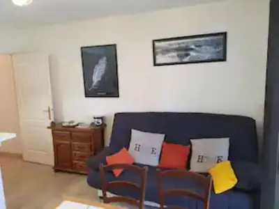 a living room with a blue couch with colorful pillows at Cannes près Croisette beau 2 pièces 3 étoiles in Cannes