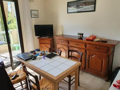 a dining room with a table and a tv at Cannes près Croisette beau 2 pièces 3 étoiles in Cannes