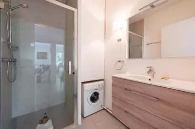 a bathroom with a sink and a washing machine at Cozy 2-Br Apartment 6 Minutes from the Beach in Cannes