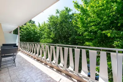 a balcony with a white railing and trees at Cozy 2-Br Apartment 6 Minutes from the Beach in Cannes