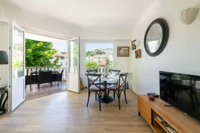 a living room with a tv and a table and chairs at Cozy 2-Br Apartment 6 Minutes from the Beach in Cannes