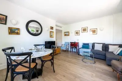 a living room with a table and a couch at Cozy 2-Br Apartment 6 Minutes from the Beach in Cannes