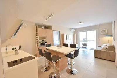 a kitchen and living room with a table and chairs at 3-Room Apartment in the Heart of Cannes in Cannes