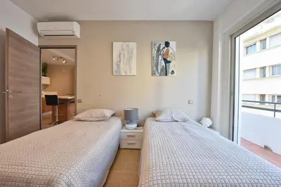 two beds sitting next to each other in a bedroom at 3-Room Apartment in the Heart of Cannes in Cannes