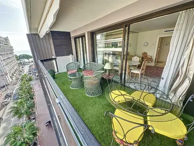 a balcony with a table and chairs on the grass at Luxury 1 bedroom Jardins Croisette 5 mins Croisette 265 in Cannes