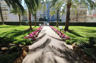 a walkway in a park with palm trees and flowers at Luxury 1 bedroom Jardins Croisette 5 mins Croisette 265 in Cannes