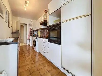 a kitchen with white cabinets and a refrigerator at Luxury 1 bedroom Jardins Croisette 5 mins Croisette 265 in Cannes