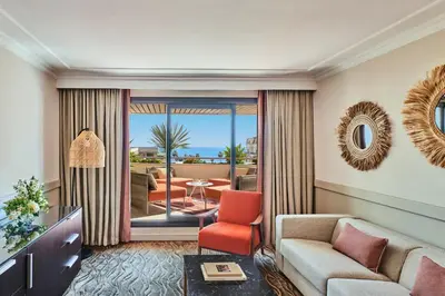 a living room with a couch and a chair at Hôtel Barrière Le Gray d'Albion in Cannes
