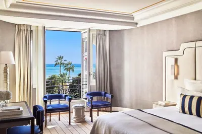 a bedroom with a bed and a view of the ocean at Hôtel Barrière Le Majestic Cannes in Cannes