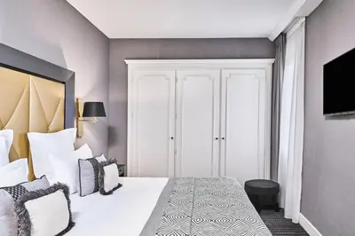 a bedroom with a large white bed with pillows at Hôtel Barrière Le Majestic Cannes in Cannes