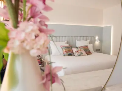a bedroom with a bed and a vase of flowers at Croisette Beach Hotel Cannes - MGallery Collection in Cannes