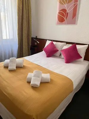 a bedroom with a bed with two towels on it at Azurene Royal Hotel in Cannes