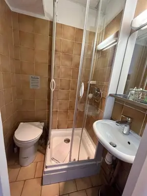 a bathroom with a shower and a toilet and a sink at Azurene Royal Hotel in Cannes