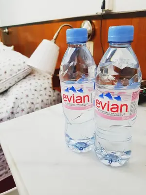 two bottles of water sitting on top of a bed at Azurene Royal Hotel in Cannes