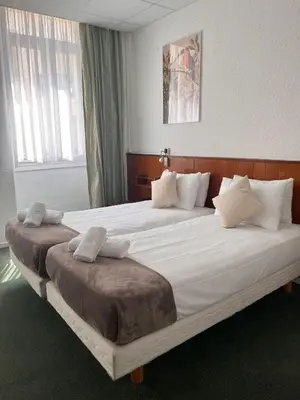 a large bed in a hotel room with two beds at Azurene Royal Hotel in Cannes