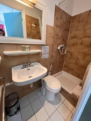 a bathroom with a sink and a toilet and a tub at Azurene Royal Hotel in Cannes
