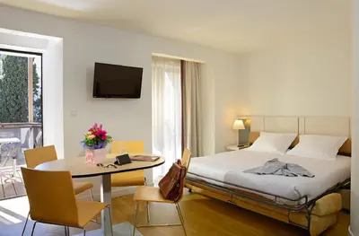 a hotel room with a bed and a table with a table at Résidence Residéal Premium Cannes in Cannes