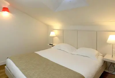 a bedroom with a large white bed with two lamps at Résidence Residéal Premium Cannes in Cannes