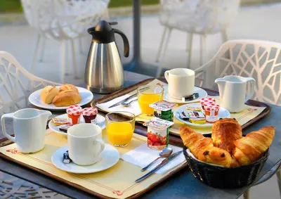 a tray of breakfast food on a table with coffee and croissants at Résidence Residéal Premium Cannes in Cannes