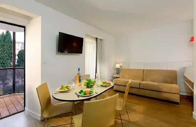 a living room with a table and chairs and a couch at Résidence Residéal Premium Cannes in Cannes