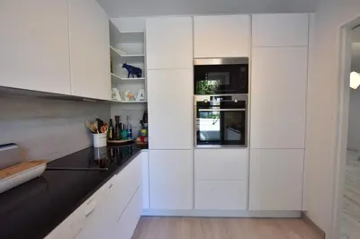 a kitchen with white cabinets and a sink at Stunning 3-Br Apartment with Large Terrace and Pool in Cannes