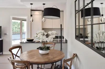 a kitchen and dining room with a wooden table and chairs at CANNES - 2-BR flat 15-min walk to the beaches in Cannes