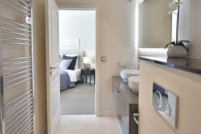 a bathroom with a sink and a bedroom with a bed at CANNES - 2-BR flat 15-min walk to the beaches in Cannes