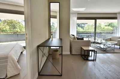 a bedroom with a bed and a living room at CANNES - 2-BR flat 15-min walk to the beaches in Cannes