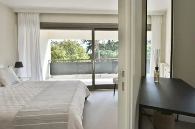 a bedroom with a bed and a desk and a window at CANNES - 2-BR flat 15-min walk to the beaches in Cannes