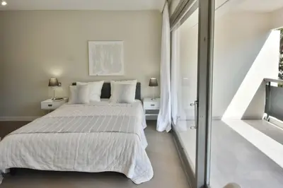 a white bedroom with a bed and a window at CANNES - 2-BR flat 15-min walk to the beaches in Cannes