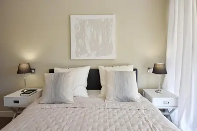 a bedroom with a bed with white pillows and two lamps at CANNES - 2-BR flat 15-min walk to the beaches in Cannes