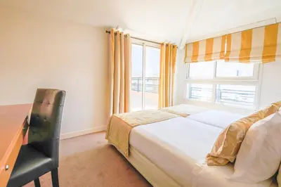 a bedroom with a bed and a desk and a window at Cannes Croisette Prestige Apart'hotel in Cannes