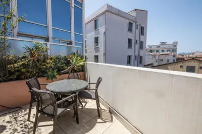 a table and chairs on the balcony of a building at Cannes Croisette Prestige Apart'hotel in Cannes