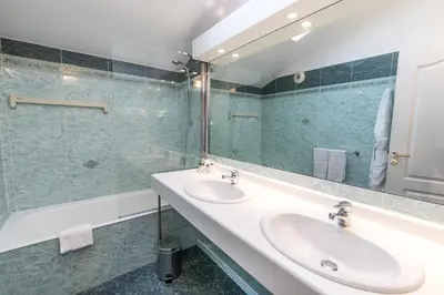 a bathroom with two sinks and a mirror at Cannes Croisette Prestige Apart'hotel in Cannes