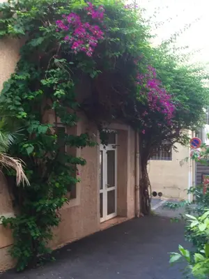 a restaurant with tables and chairs and a kitchen at Appia Hotel in Cannes