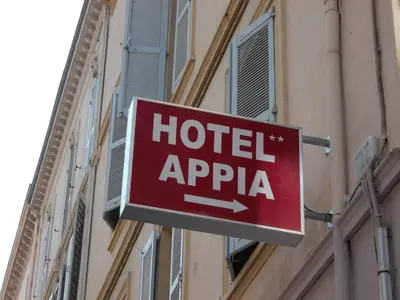 a room with a kitchen with a counter and chairs at Appia Hotel in Cannes